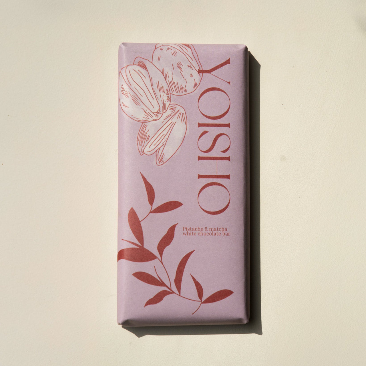 Pink chocolate bar with 'YOISHO' branding on a beige background